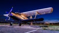 Old vintage classic airplane on small airfield in night time with clear sky. Abandoned biplane in long exposure under the stars Royalty Free Stock Photo