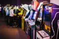 Old Vintage Arcade Games in a dark room and players playing in the background