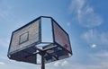 Old and vintage basketball backboard and hoop. Basketball hoop on a background of blue sky and white clouds.