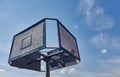 Old and vintage basketball backboard and hoop. Basketball hoop on a background of blue sky and white clouds. Royalty Free Stock Photo