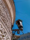 Old vintage black glass street lantern hanging on textured wall of beautiful round building in city of Saint Petersburg in light Royalty Free Stock Photo