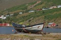 Old vintage boat with a small town of Eskifjodur located in east Iceland in the background Royalty Free Stock Photo