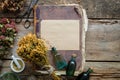 Old vintage book, tincture bottles, assortment of bunches of dry medicinal herbs, mortar. Herbal medicine.