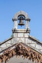 Old vintage brass bell on a ancient stone chapel on a blue sky b Royalty Free Stock Photo