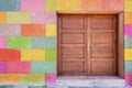 Old vintage brown painted wooden door and colorful painted blocks on wall. Royalty Free Stock Photo
