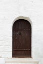 Old vintage brown wooden door in old white stone wall. Royalty Free Stock Photo