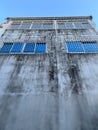 Old vintage building with wrought  iron window on mottled wall under clear blue sky Royalty Free Stock Photo