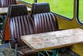 Old vintage bus seats with a wooden table, interior of a old retro school bus Royalty Free Stock Photo