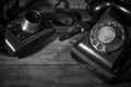 Old vintage camera and a telephone on a desk, cinematic noir scene Royalty Free Stock Photo