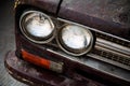 Old, vintage car headlight close-up. Shabby, rough antique trans