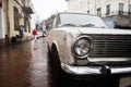 Old vintage car headlight in rain city street