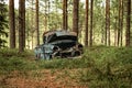 Old vintage car wreck standing in a forest in Sweden