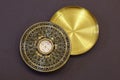 Old vintage chinese compass used in feng shui, golden item with hieroglyphs and cover, on dark background. Royalty Free Stock Photo