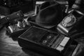 Old vintage cinematic noir scene, detective`s desk with a hat, telephone, camera, portable cassette recorder, and whisky