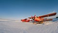 Old vintage classic airplane on snow covered airfield. Abandoned biplane in summer winter day with clear sky after snowfall