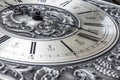 Old vintage clock with metal dial and floral embossed pattern close-up. Black clock hands indicating a time of 6 hours. Beautiful Royalty Free Stock Photo