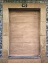 Old and vintage closed window with wooden shutter in a granite stone wall and blue tiles, with number 40 on top Royalty Free Stock Photo