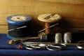 OLD VINTAGE COTTON REELS WITH THREAD AND NEEDLES, A TRACING WHEEL, SCISSORS AND THIMBLES