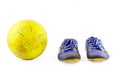 Old vintage damaged futsal sports shoes and ragged yellow ball on white background football object isolated Royalty Free Stock Photo