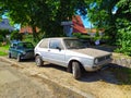 Old vintage dusty light grey VW Golf one parked