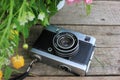 Old vintage film photo camera and flowers on wooden background with copy space. Royalty Free Stock Photo