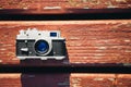 Old vintage film photo camera lying on wooden background. Copy space. Top view Royalty Free Stock Photo
