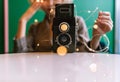 Old vintage film two lens camera surrounded by fairy lights with the blurred female silhoutte in the back Royalty Free Stock Photo