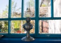 Old vintage gas lamp standing in the house on blue scratched window sill. Rustic natural photo Royalty Free Stock Photo