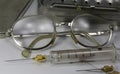 Old vintage glasses of a doctor and the syringe of glass