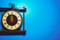 Old vintage gold clock in a wooden frame on a blue background Royalty Free Stock Photo