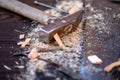 Old vintage hammer, wood saw, nails and sawdust on a wooden background, close-up, selective focus Royalty Free Stock Photo