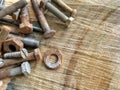 Old vintage hand tools - set of screws and nuts on a wooden background. A lot of old rustic screws