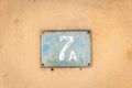 Old vintage house address metal plate number 7 A seven on the plaster facade of abandoned home exterior wall on the street side Royalty Free Stock Photo