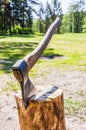 Iron ax with wooden handle stuck in the log