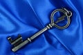 Old vintage key in blue satin Royalty Free Stock Photo