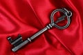 Old vintage key in red satin cloth Royalty Free Stock Photo