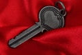 Old vintage key in red satin cloth Royalty Free Stock Photo