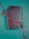 Old vintage keys with red atlas ribbon and old brown books on dark green background