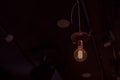 An old vintage lamp, illuminated from the inside by gold threads, hangs on the ceiling in the bar. Dark background