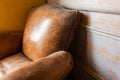 Old vintage leather armchair with wood background Royalty Free Stock Photo