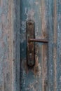 Old vintage metal door handle on old blue wooden doors. Rusty door handle Royalty Free Stock Photo