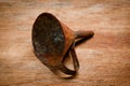 Old vintage metal funnel for filling liquid of the last century extracted from a chest in the workshop of grandfather. Background Royalty Free Stock Photo