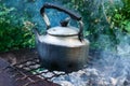 Old vintage metal kettle on an open fire on a nature Royalty Free Stock Photo