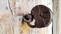 Old vintage metal padlock on a closed wooden door of an old farmhouse. The true style of the village. close-up. focus on the Royalty Free Stock Photo