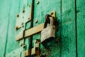 An old vintage metal padlock closes the wooden painted gate with a latch Royalty Free Stock Photo