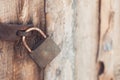 The old and vintage metal padlock with rust on the wooden door, locked for security Royalty Free Stock Photo