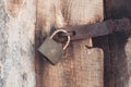 The old and vintage metal padlock with rust on the wooden door, locked for security Royalty Free Stock Photo