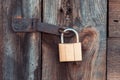 The old and vintage metal padlock with rust on the wooden door, locked for security Royalty Free Stock Photo