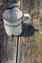Old vintage metallic cup for 1000 grams stands on wooden background