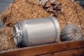 Old vintage milk churns. Aluminium Can for milk or water. Wooden Cart and logs as background Royalty Free Stock Photo